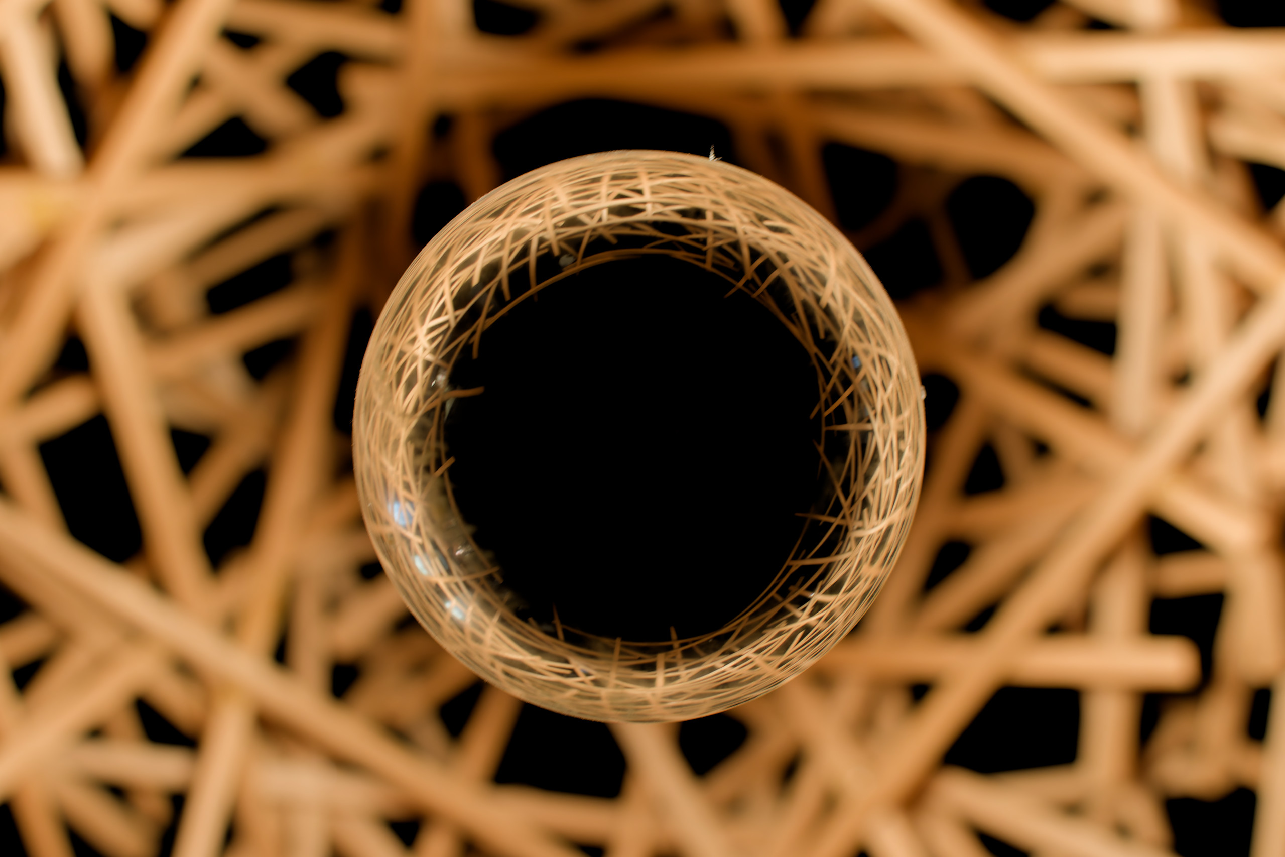 Close up of a lightbulb in a lamp that my dad made (out of chopsticks). © 2024. This work is openly licensed via CC BY-NC 4.0
